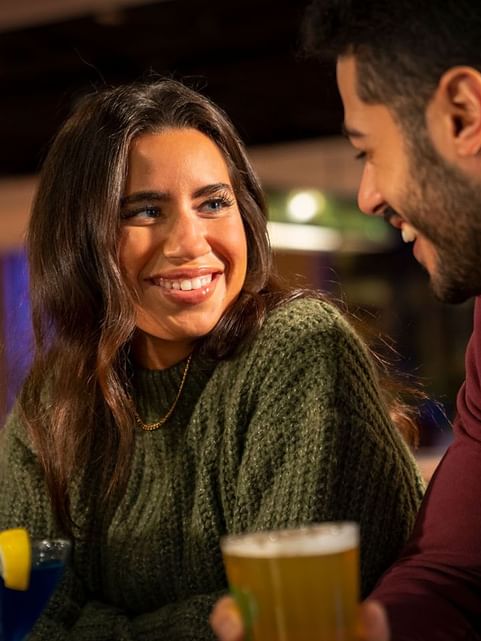 Couple gazing at each other while enjoying their drinks from The Restaurant at Cove Pocono Resorts