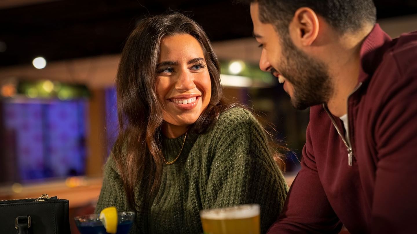 Couple gazing at each other while enjoying their drinks from The Restaurant at Cove Pocono Resorts