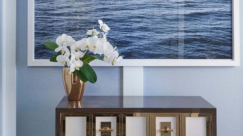 Flower vase on a desk beside a wall art at Crown Hotels Perth