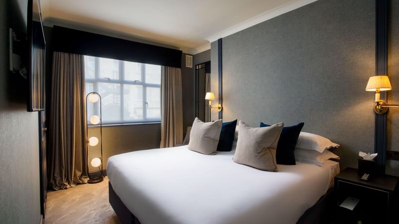 Stylish hotel room with a modern floor lamp and a large king-sized bed at Warwick Hotels and Resorts