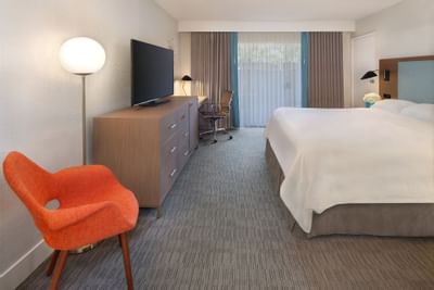 Comfy bed, TV, chair in King room at The Anaheim Hotel