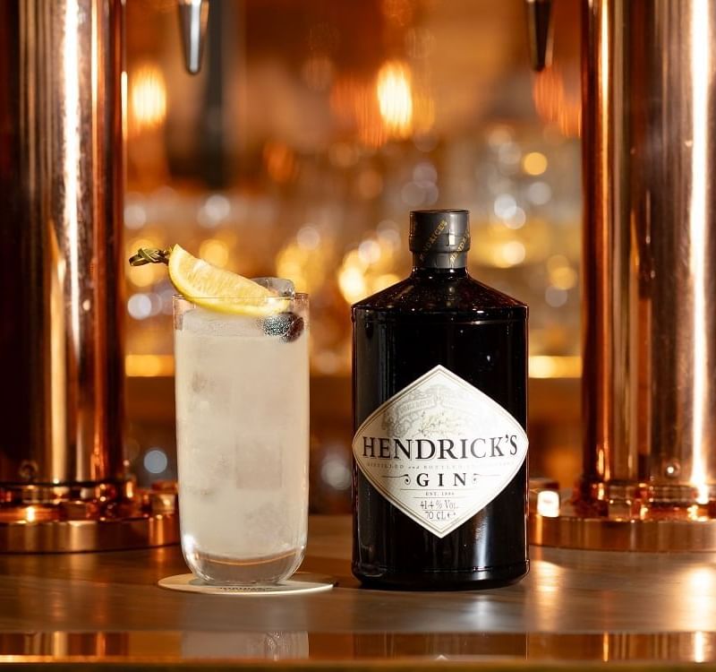 Henrick's gin bottle and Tom Collins cocktail in Joshua's Tavern at The Londoner Hotel