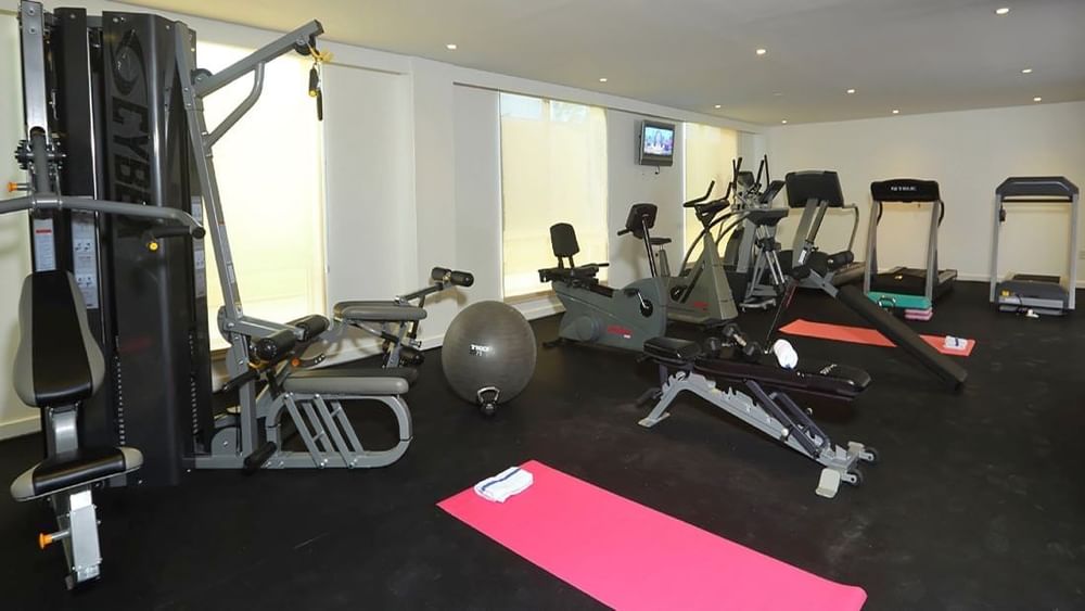 Modern fitness center with cardio machines and pink yoga mats at Warwick Paradise Island Bahamas