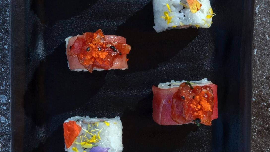 Plato negro para servir con varios rollos de sushi decorativos en La Terraza del Santo de Hacienda del Mar Los Cabos.
