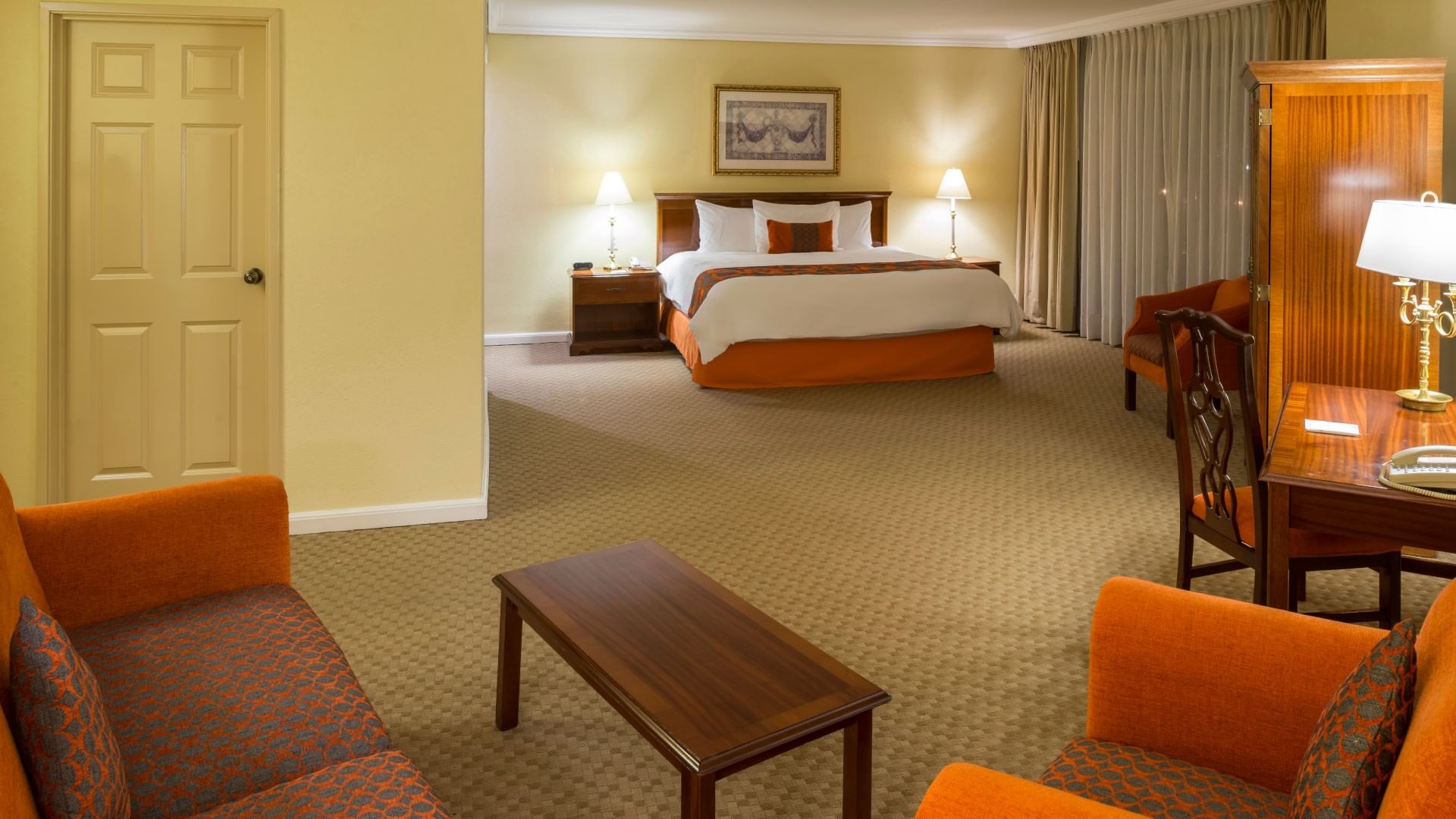 Junior Suite King con cama king, sala de estar y muebles de madera en Camino Real Puebla Angelópolis