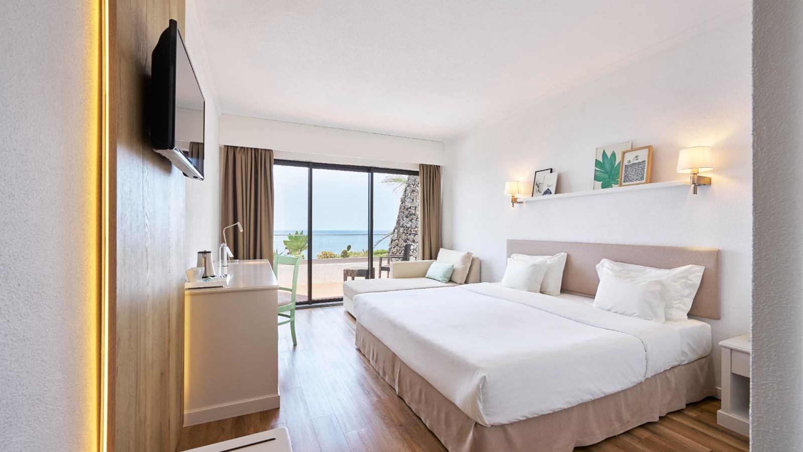 TV and work desk facing the cozy bed in Superior Ocean View with wooden flooring at Bensaude Hotels