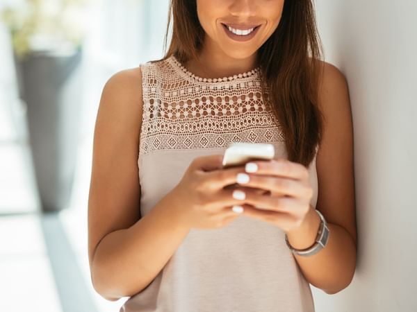 Woman intently looking at her smartphone at Coast Penticton Hotel