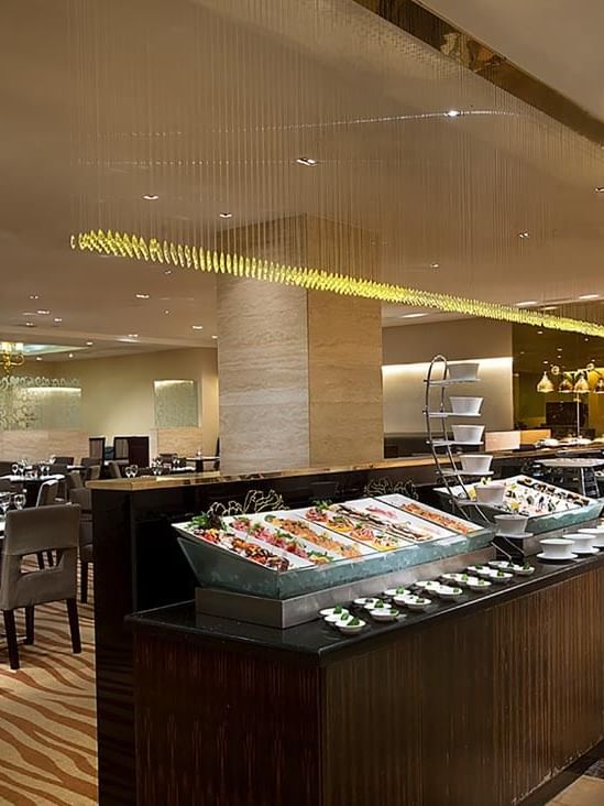 Opened buffet and dining tables arranged in Rainbow Room Coffee Shop at Celebrity International Grand Hotel