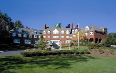 Large brick building with many windows in front of a green lawn exterior view at The Simsbury Inn