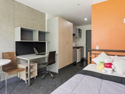 Bedroom with desk, chair, and small kitchen area at Student Living Auckland - Beach.
