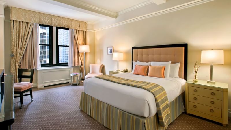 Comfy bed with side tables and sitting area in Accessible Premier City View at Warwick New York