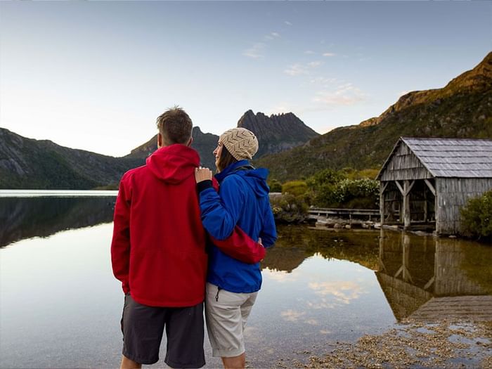 Landscape view of a couple close together enjoying the lake view near Freycinet Lodge