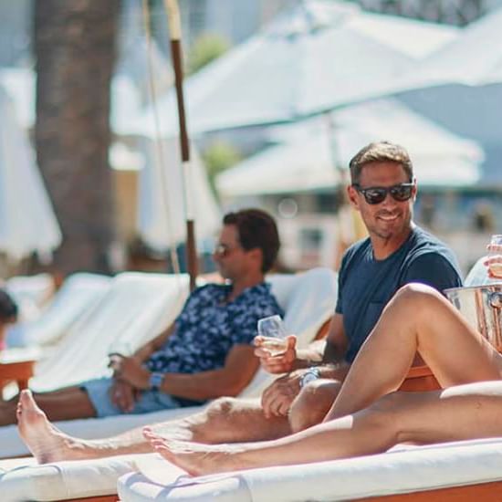 People relaxing on sun loungers under parasols at Catalina Island Company