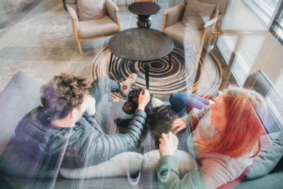 Couple petting a dog in the lounge area at Aava Whistler Hotel