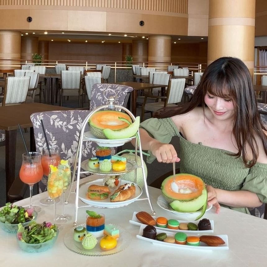 A lady enjoying high tea treats in a restaurant at Park Hotel Group