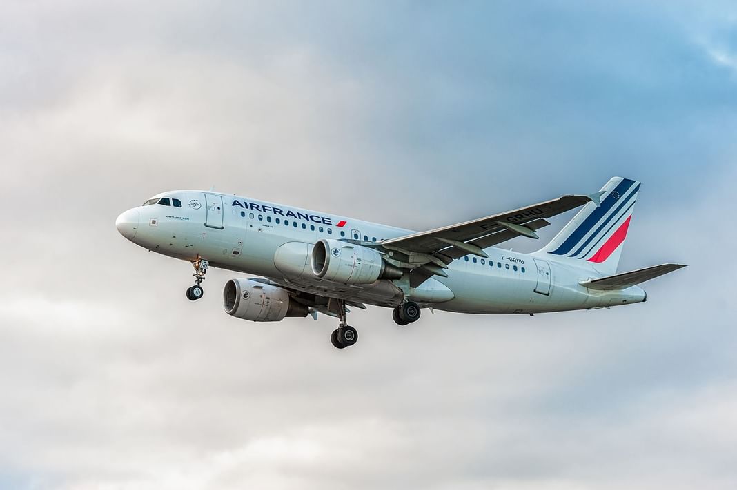 Airbus A320-200 d'Air France volant dans un ciel bleu clair près des Hôtels Oceania
