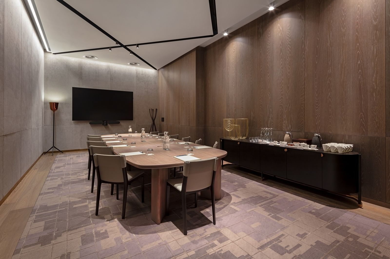 Maddox Gallery meeting room at The Londoner Hotel, set with a large table, modern chairs, and a wall-mounted TV