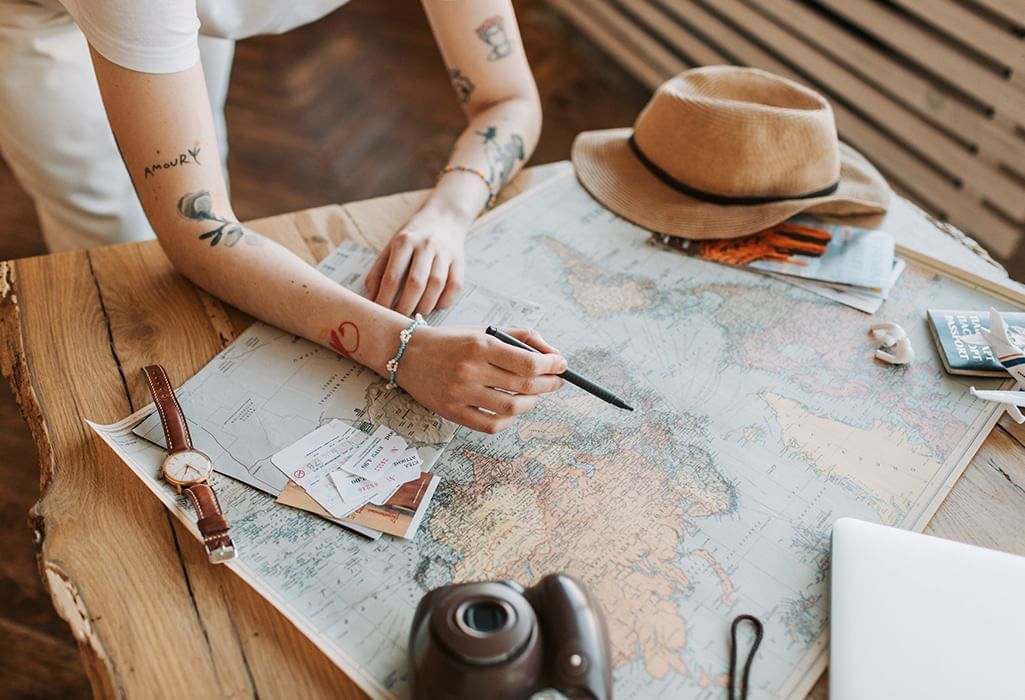 planning travel with a paper map, camera and coffee