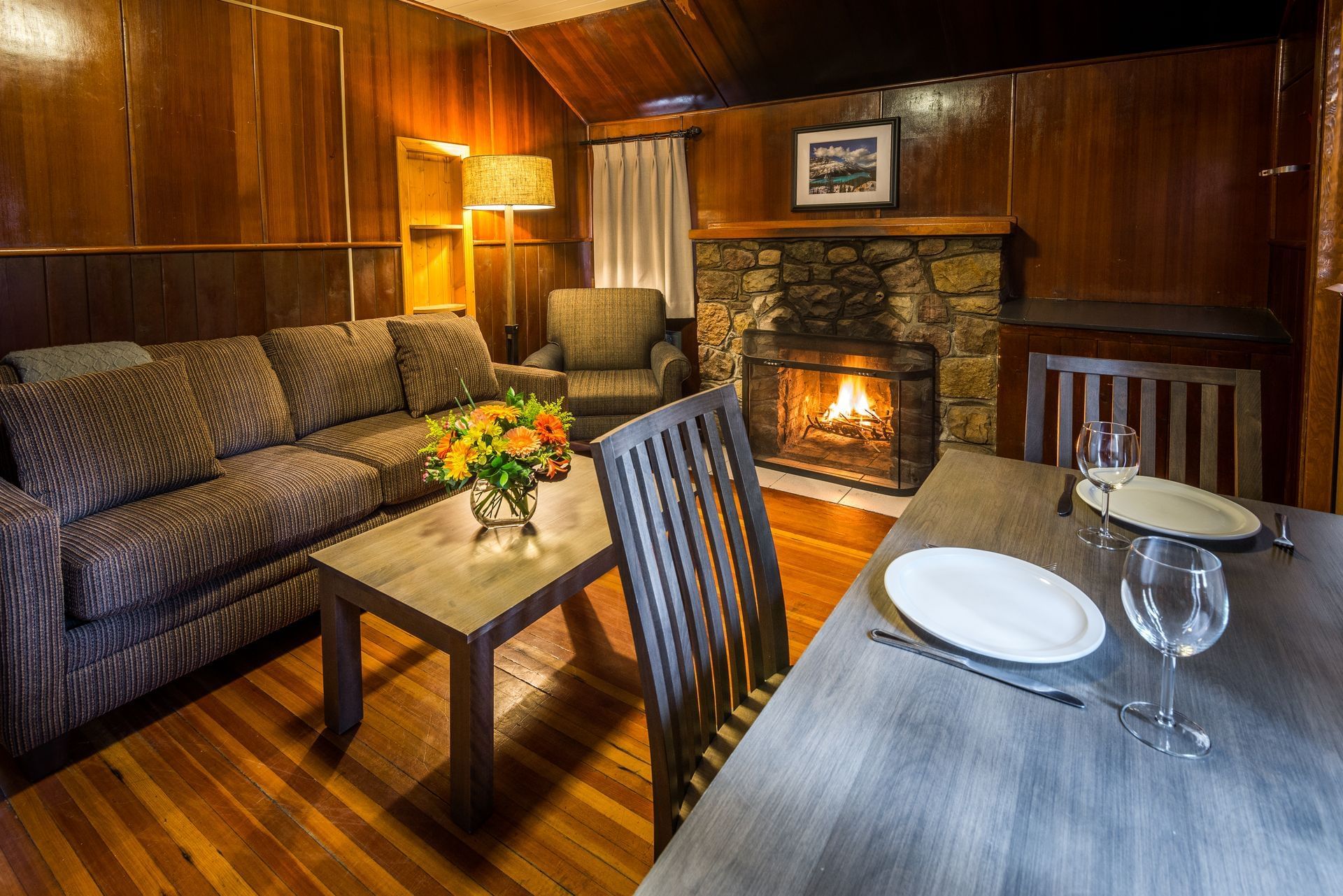 Dining table, sofa and fireplace in lodge