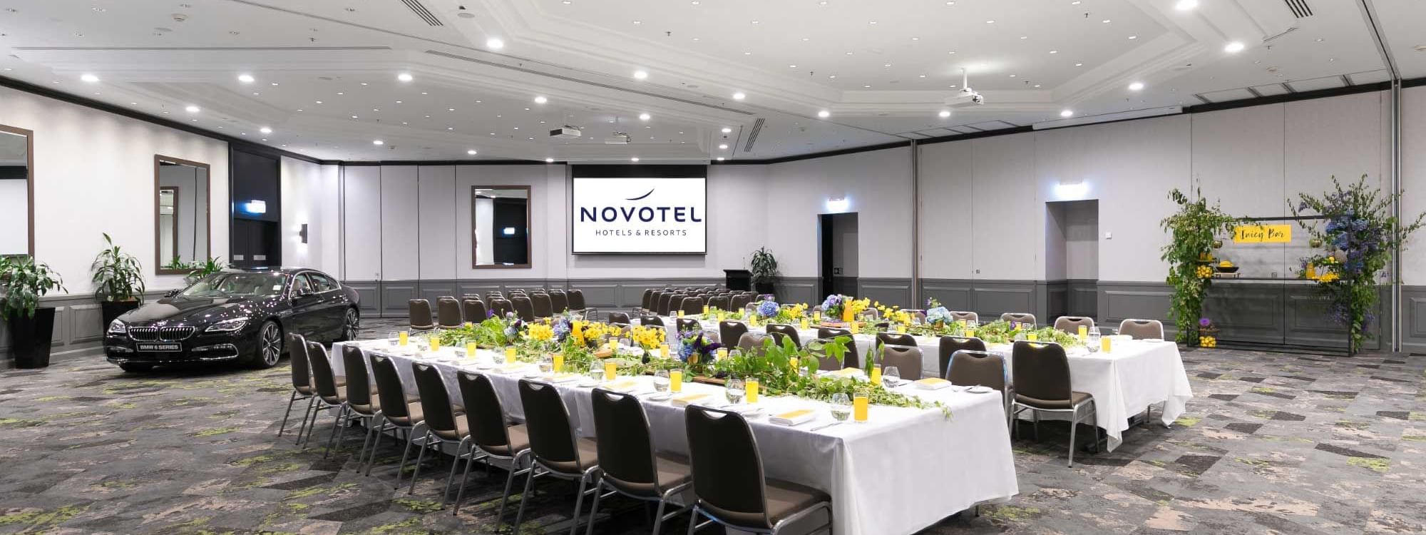 Grand Ballroom with setup tables and a car display at Novotel Sydney International Airport
