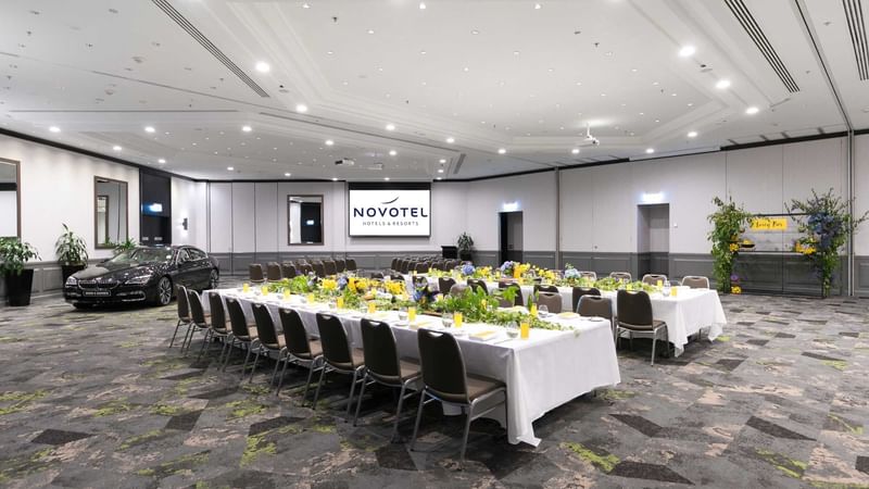 Grand Ballroom with setup tables and a car display at Novotel Sydney International Airport