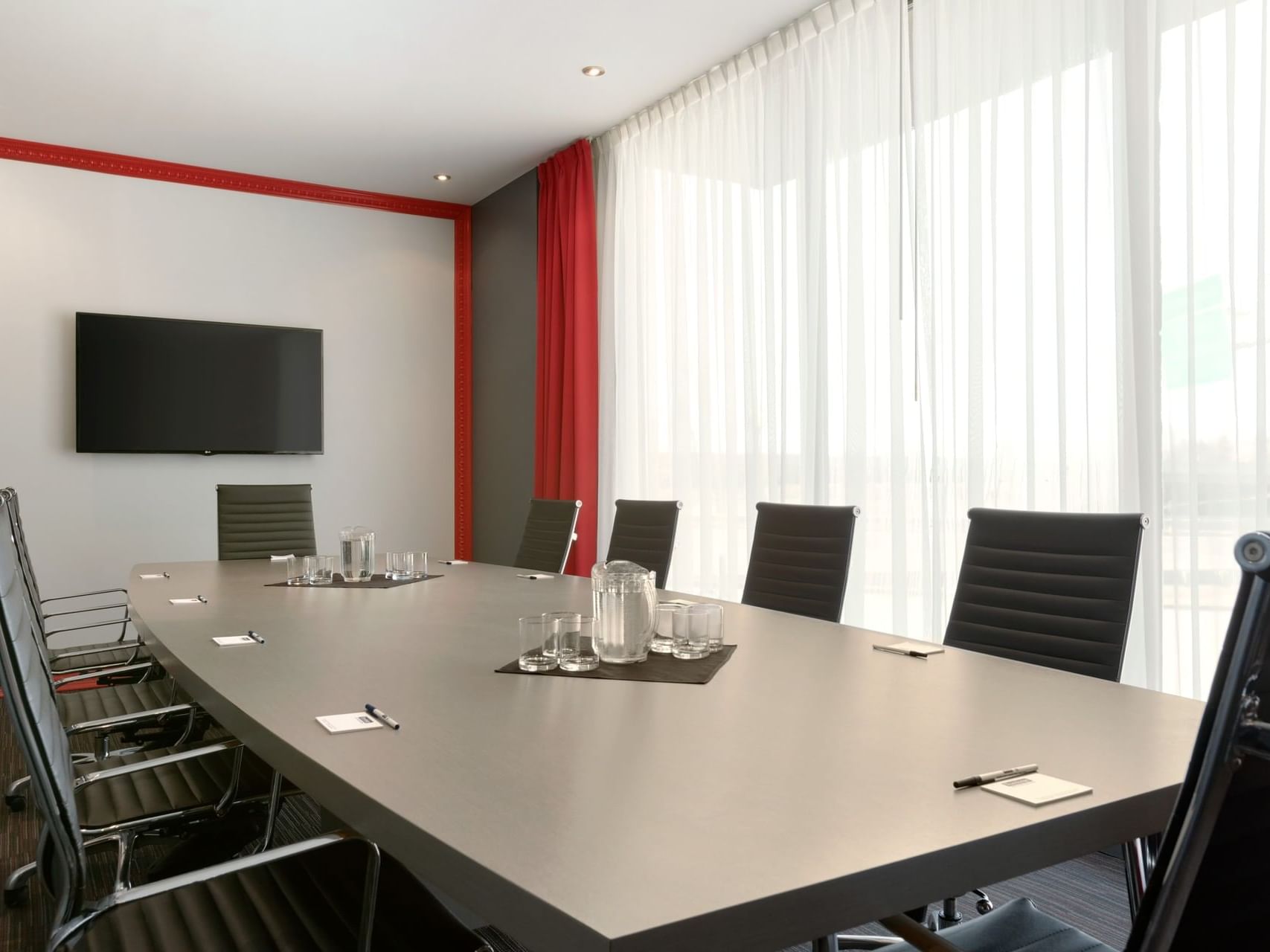 Conference table with wall-mounted TV in Beaupré at Travelodge Hotel & Convention Center Québec City