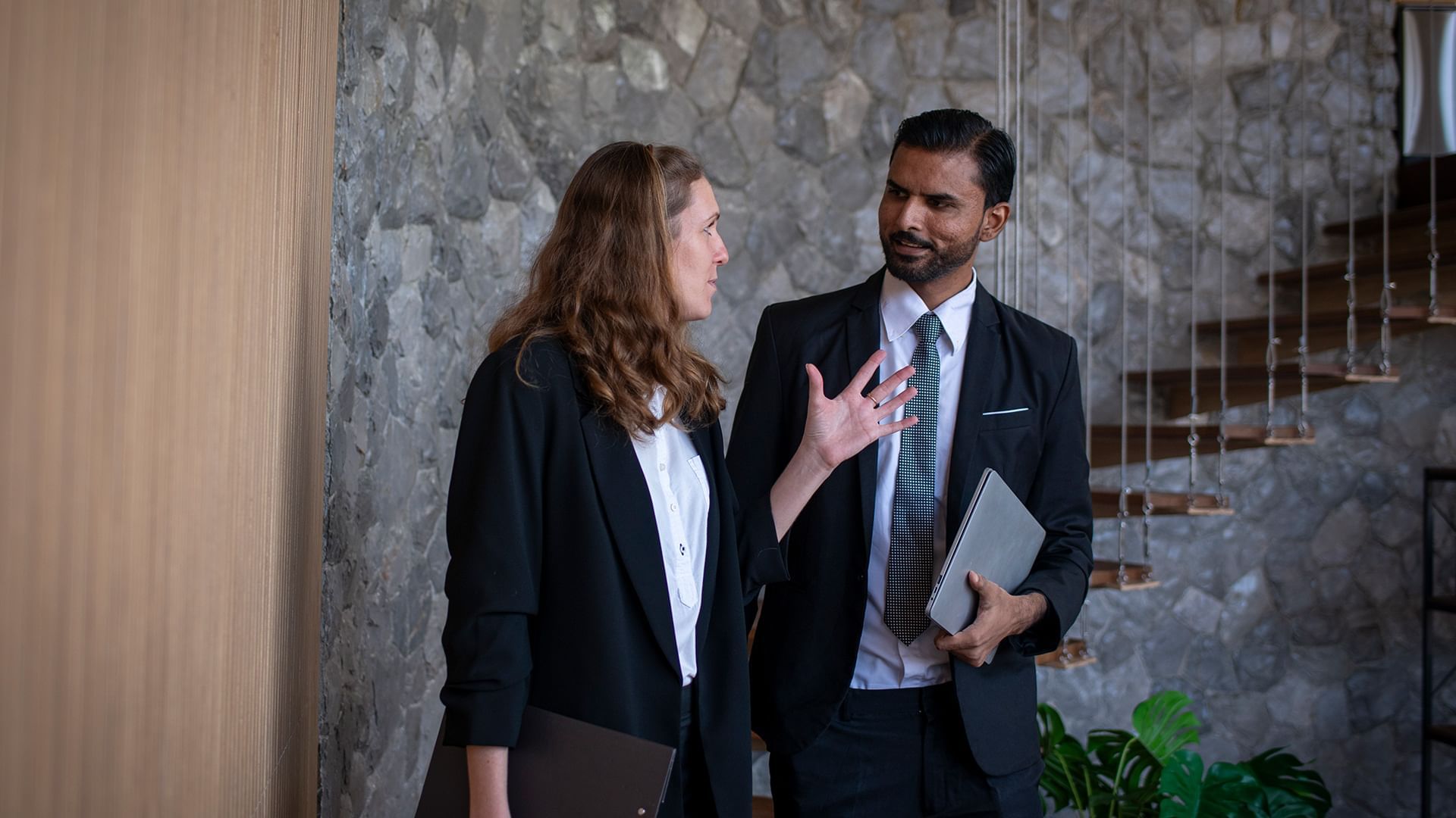 A man and woman in formal attire having a discussion.
