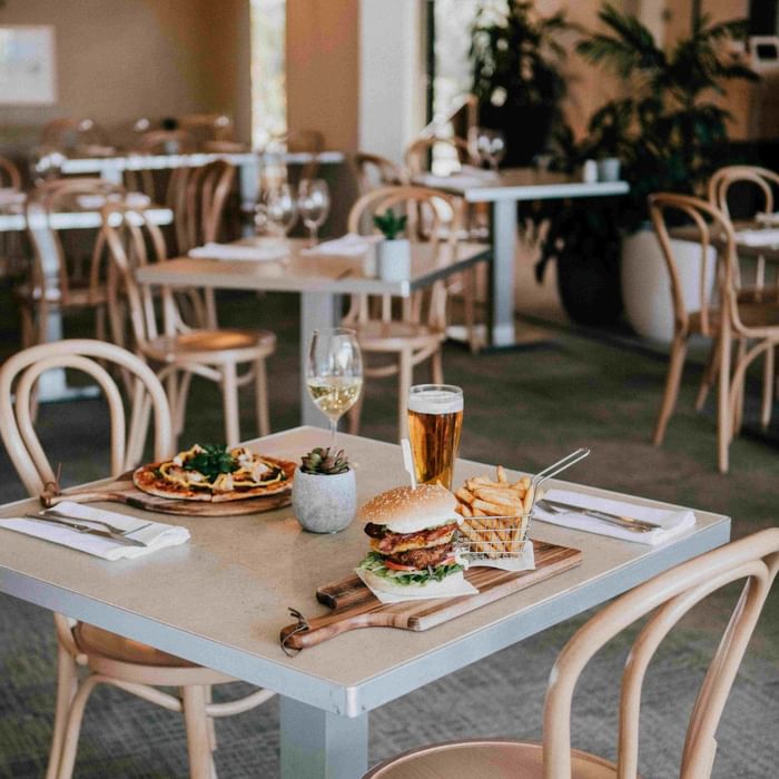 Empty restaurant dining area with table set for two and food at Mercure Charlestown.
