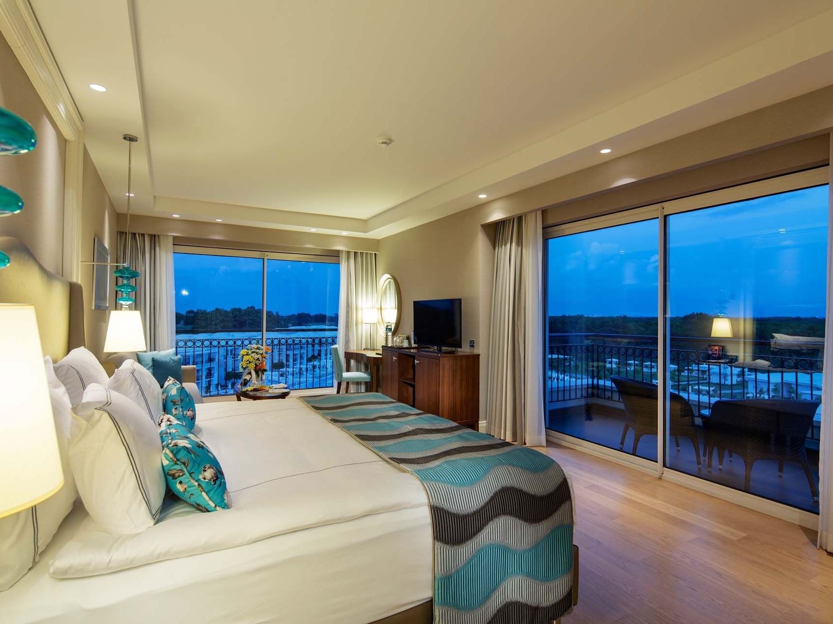 TV lounge area by the bed in Corner Suite with a balcony view at Titanic Deluxe Golf Belek