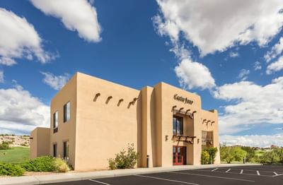 Exterior of Casino Inn at Hilton Santa Fe Buffalo Thunder with desert landscaping under a clear blue sky