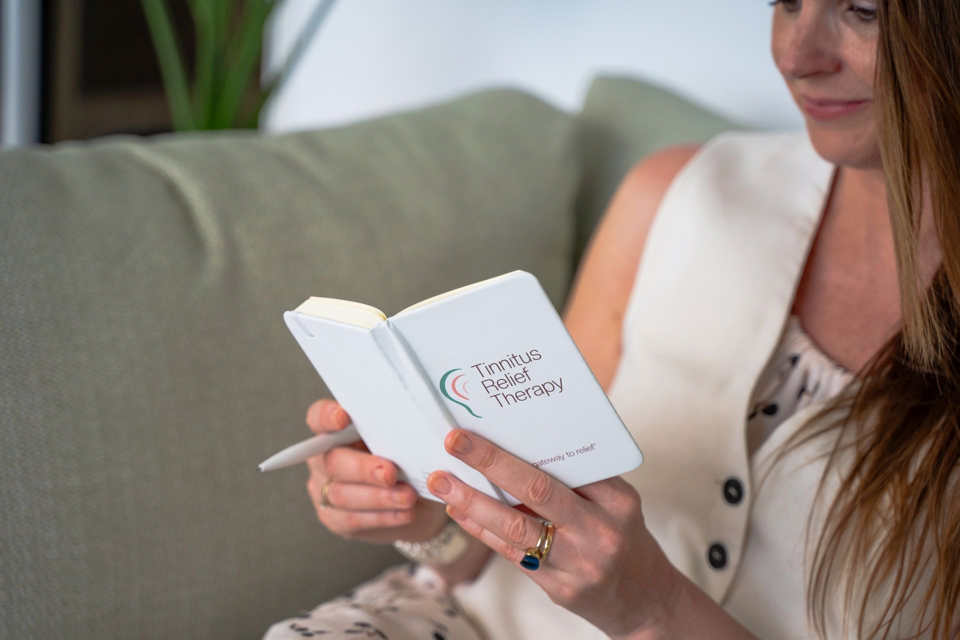 Guest reading personalized notebook during consultation for Tinnitus Relief Therapy at Golden Rock Resort