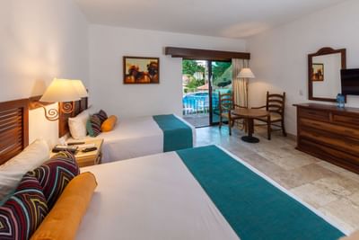 Hotel room with two beds, a table, chairs, a pool view, and a flat-screen TV on the dresser.