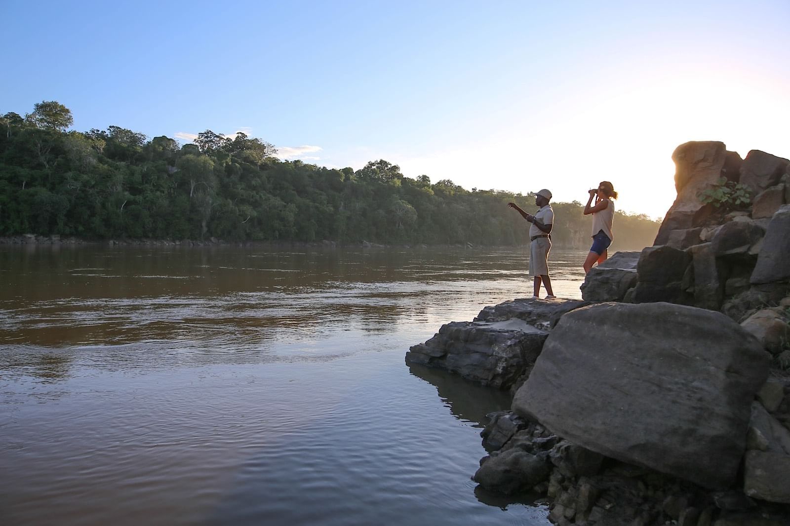 Tourists on a rock by the river near Serena Mivumo River Lodge