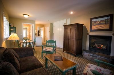 Living room within suite including couch, dining area and firepl