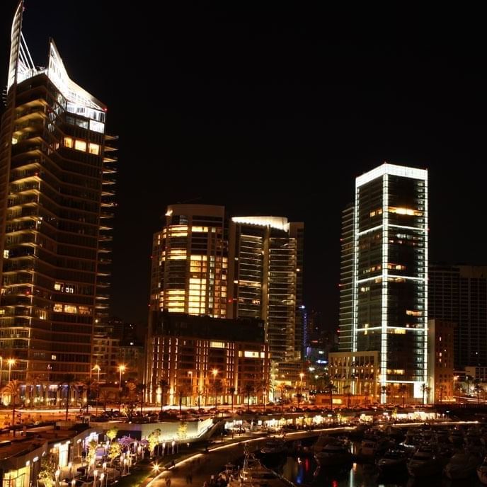 Skyline of Zaitunay Bay at night, featuring lit towers by the marina near the Warwick Palm Beach Hotel
