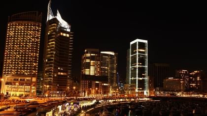 Skyline of Zaitunay Bay at night, featuring lit towers by the marina near the Warwick Palm Beach Hotel
