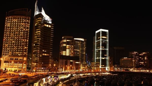 Skyline of Zaitunay Bay at night, featuring lit towers by the marina near the Warwick Palm Beach Hotel