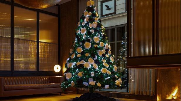 Cozy lounge area with Christmas tree decorations at The Londoner Hotel