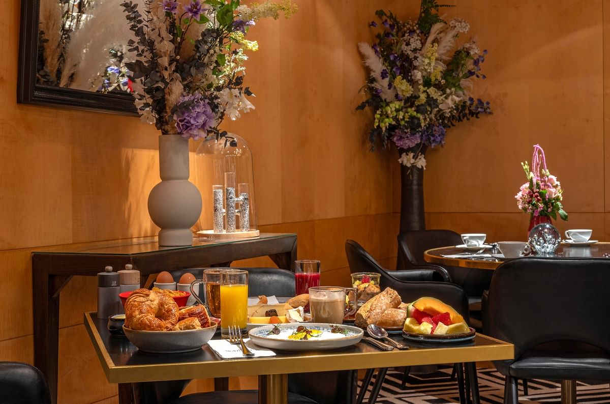 Gourmet breakfast by fruit under floral vases surrounding a table at Warwick Paris Champs Elysées