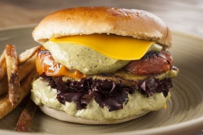Close-up of a burger dish served in Bar Vistandes, featuring hotels with restaurant in Santiago at Hotel Nodo