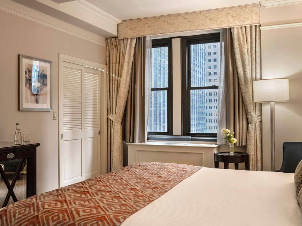 Premier City view room corner view of king bed & louvered closet doors, and city view windows at Warwick New York