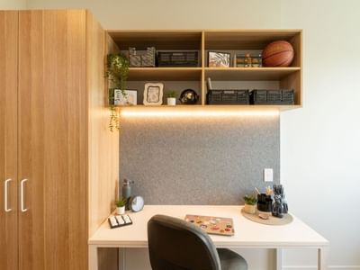 Modern workspace with desk, chair, storage cabinet, and shelves at UniLodge Brisbane City.