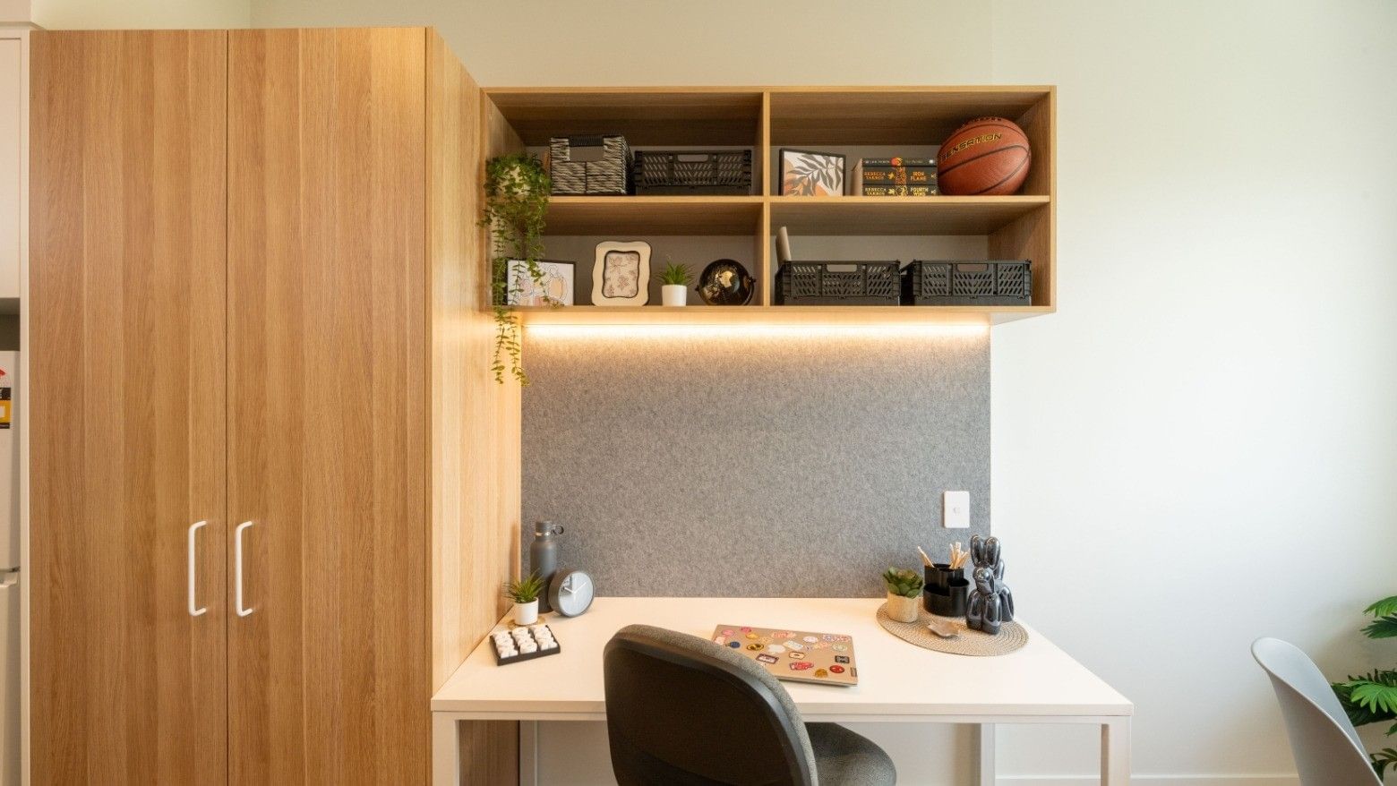 Modern workspace with desk, chair, storage cabinet, and shelves at UniLodge Brisbane City.