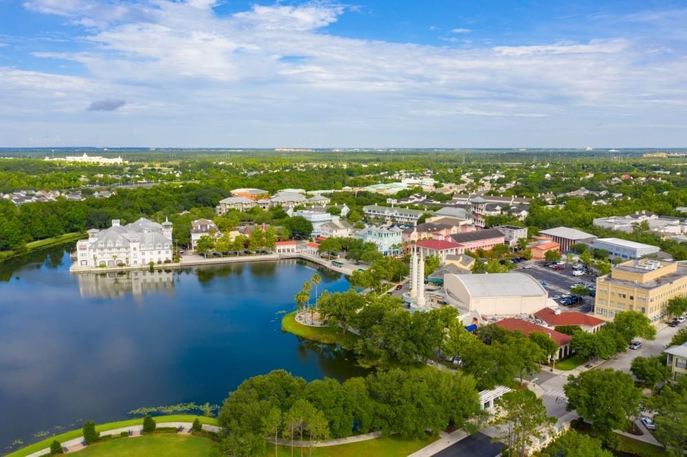 An aerial shot of downtown Celebration with a large lake, plenty of trees, and colorful buildings. 