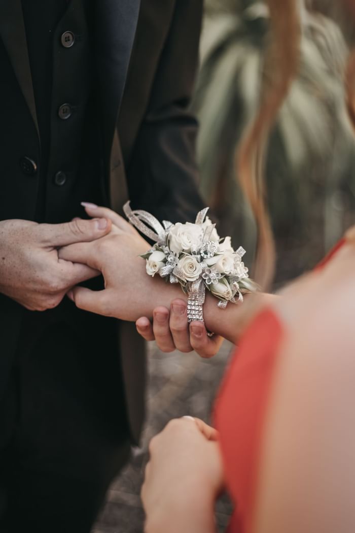 Close-up of a wrist corsage exchange between a couple on a wedding at Sofitel Brisbane Central
