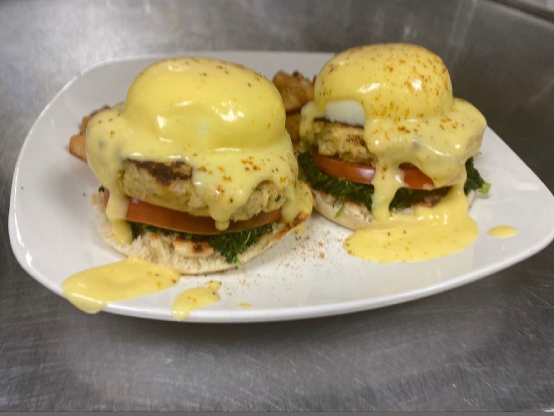 Two eggs benedicts with hollandaise sauce served in The Boca Beach House near Ocean Lodge Boca Raton