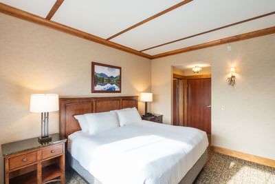 King Room at Lake Placid Club Grandview featuring a wooden headboard, nightstands, and warm wall sconces