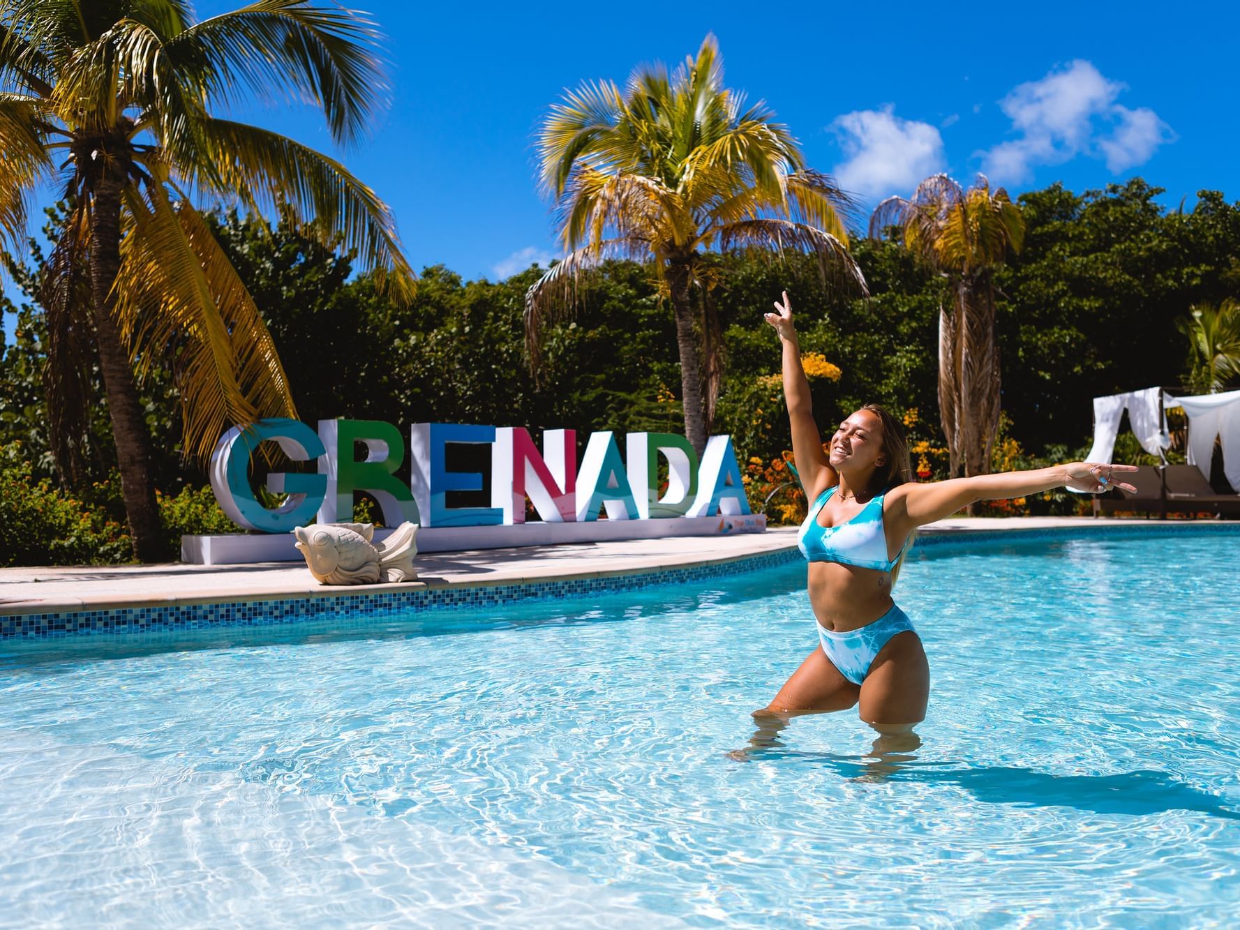 A lady in the outdoor swimming pool at True Blue Bay Hotel