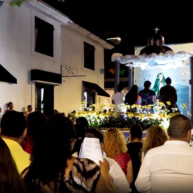 Crowd observes a religious float during a nighttime near Villa Premiere Boutique Hotel & Romantic Getaway
