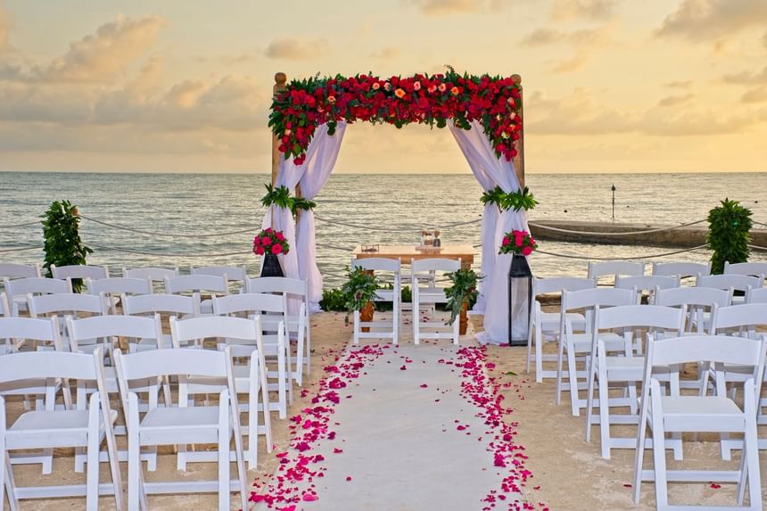Outdoor wedding ceremony with chairs, and floral deco on beach near Hotel Isla Del Encanto